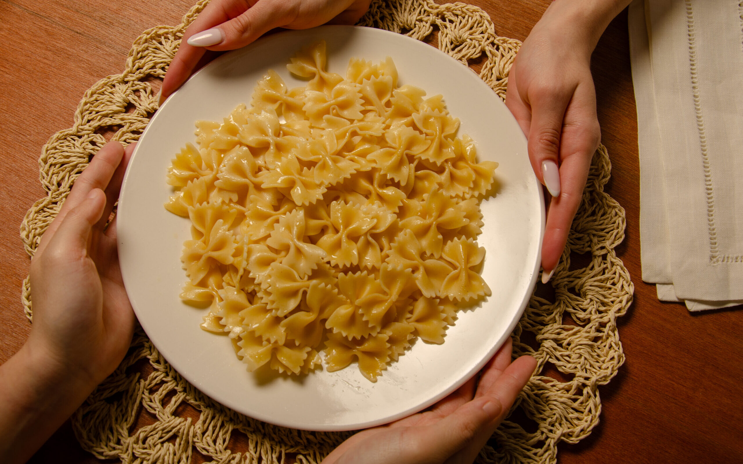 Pasta plate being held by two hands
