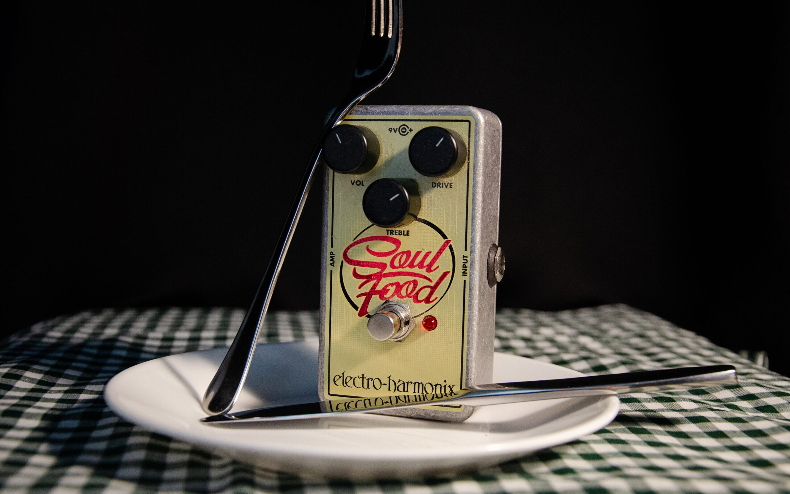 Guitar effects pedal on a plate with utensils
